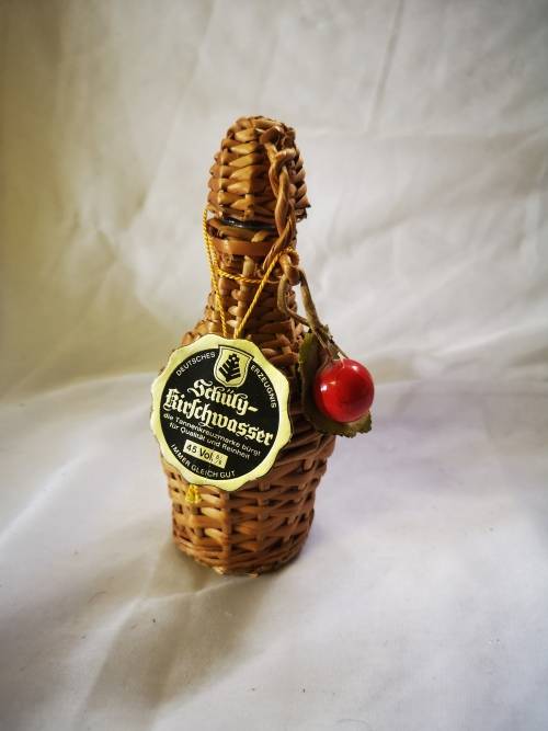 A small bottle of liquor in a beautiful woven basket - still sealed