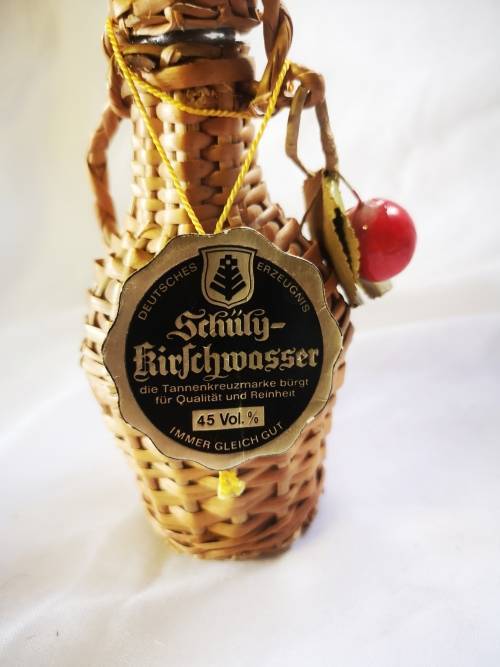 A small bottle of liquor in a beautiful woven basket - still sealed