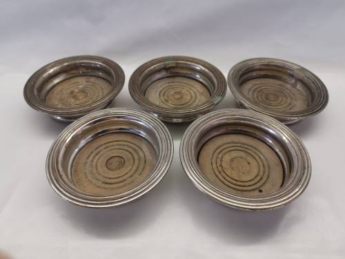 FIVE VICTORIAN SILVERPLATE BOTTLE COASTERS