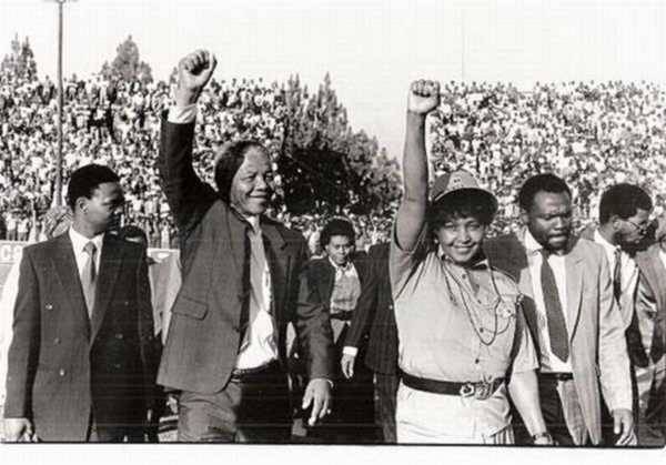 With Winnie Mandela giving black power sign.