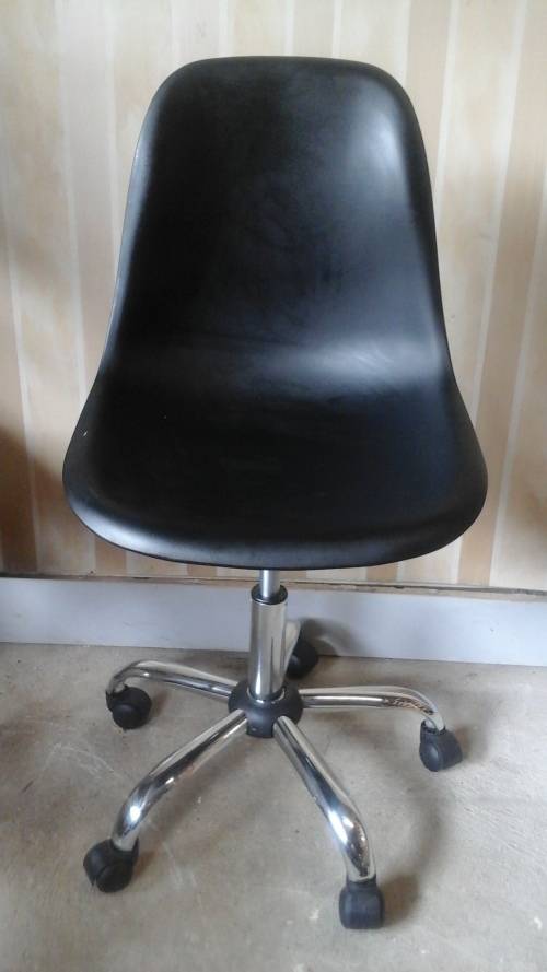 DEFINITLY DIFFERENT A PLASTIC BUCKET TYPE CHAIR THAT HAS CHROME LEGS AND WHEELS