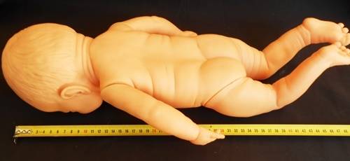 Newborn baby girl doll in new outfit knitted for her.
