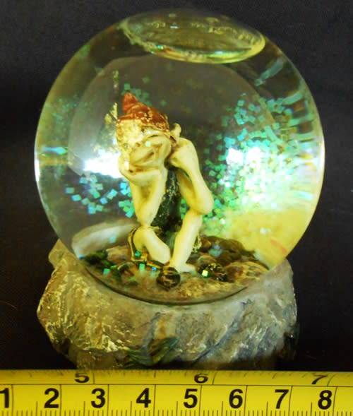 glass glitterball with fairy figure on resin base.