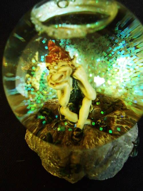 glass glitterball with fairy figure on resin base.