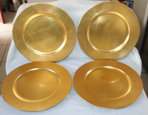 A COLLECTION OF FOUR STYLISH GOLDEN UNDER PLATES