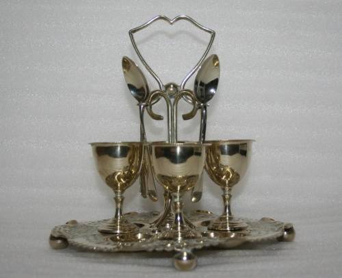 A Marvelous Very ornate silver plated egg cup Cruet stand and spoons.