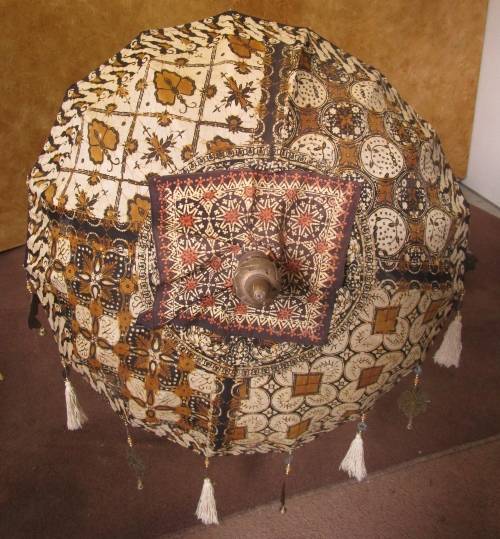 A BEAUTIFUL LONG INDIAN UMBRELLA DECORATED WITH BELS - TUSSLES EX