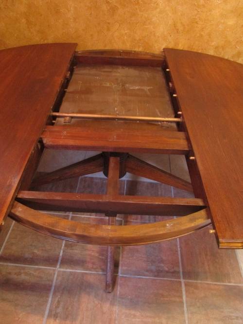 A VERY LARGE OVAL TO ROUND EXTENDABLE TABLE WITH BEAUTIFUL LEGS