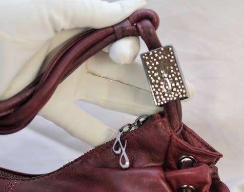 GENUINE JENNIFER LOPEZ (JLO) BURGUNDY ORIGINAL LEATHER 'HOBO' HANDBAG WITH TASSEL DETAILS.