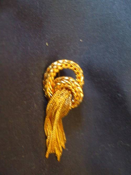 Small gold toned brooch with tassles