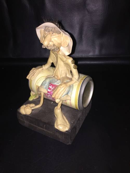 Castle lager man sitting on tin