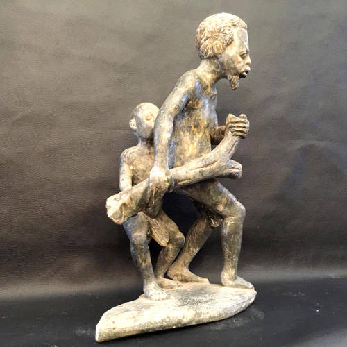 Stone Sculpture of Father and son carrying a tree