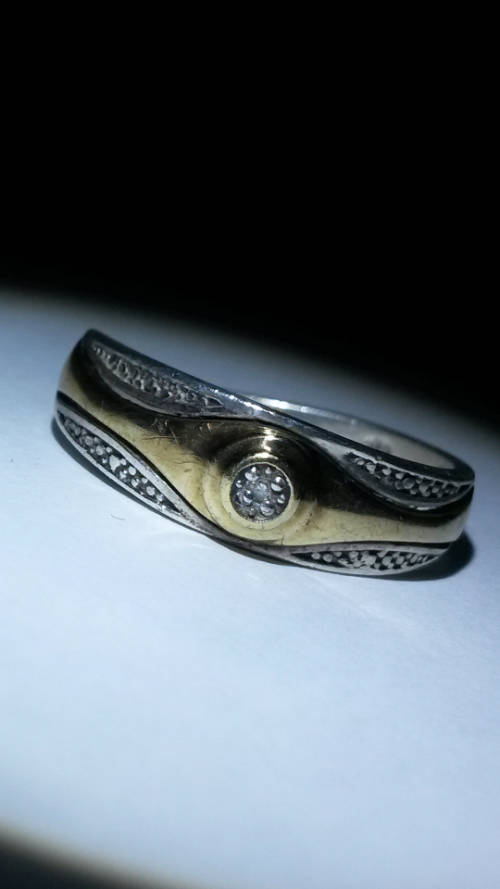 A STUNNING STERLING SILVER 9CT GOLD RING WITH NATURAL DIAMOND IN CENTER.