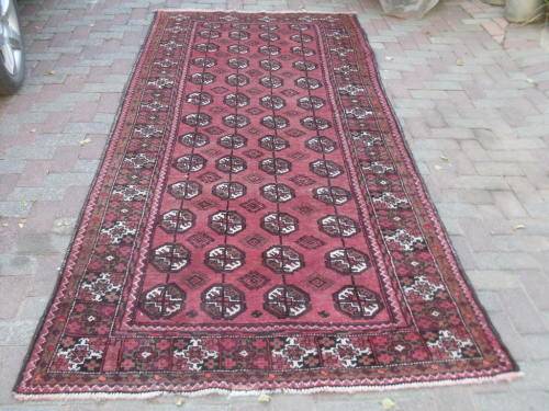 A LOVELY HAND KNOTTED PERSIAN BALOUCH CARPET WITH REPETITIVE GUL DESIGN TONED DOWN REDS BROWN IVORY