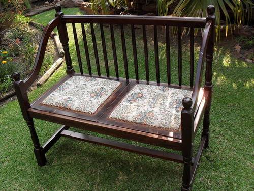 THIS IS AN EXTREMELY APPEALING DOUBLE SEATER SPINDLE BACK STAINED WOOD BENCH WITH UPHOLSTERY