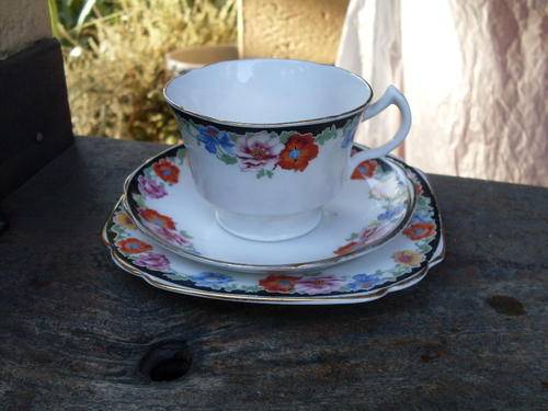 MELBA WARE BONE CHINA TEA TRIO COLOURFUL FLORAL WITH BLACK ON A WHITE BACKGROUND & GILT