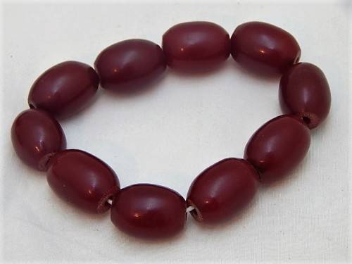 A RED AFRICAN AMBER BEADED BRACELET WITH 10 BEADS