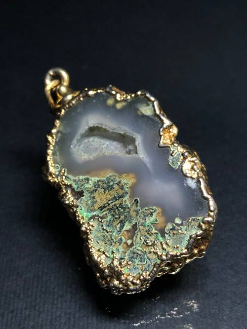 A BESPOKE GREY AGATE PENDANT WITH GOLD GILDED EDGING
