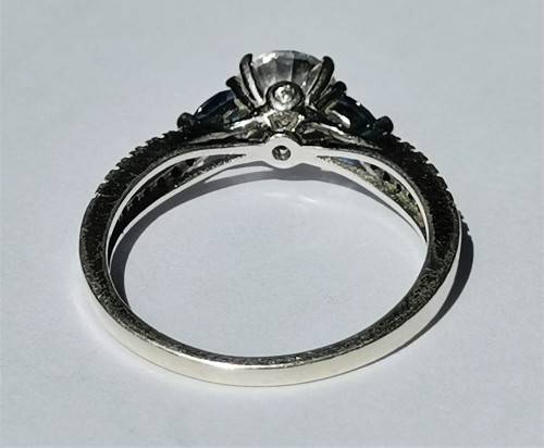 BEAUTIFUL SILVER RING WITH CLEAR MAIN STONE AND TWO BLUE STONES. WEIGHT: 2.5 GRAMS.