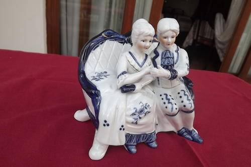 White and blue porcelain ornament of couple on couch.Good condition.Height 14cm.Length 15cm