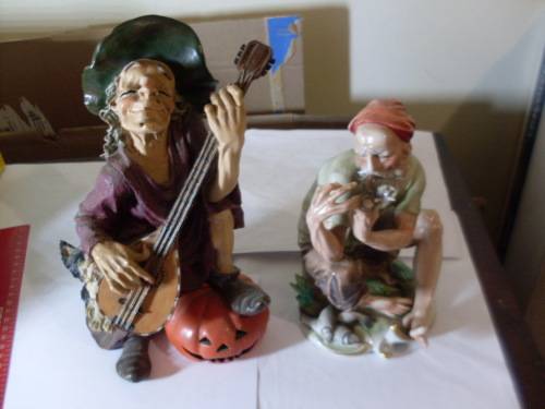 2 FIGURINES...A WITCH WITH GITAAR PUMPKIN AND CAT + A FISHERMAN HAVING A SMOKE BREAK