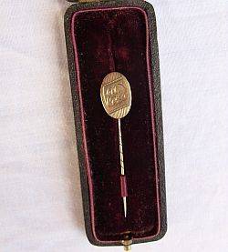 A 9ct gold stick pin in an old pin box