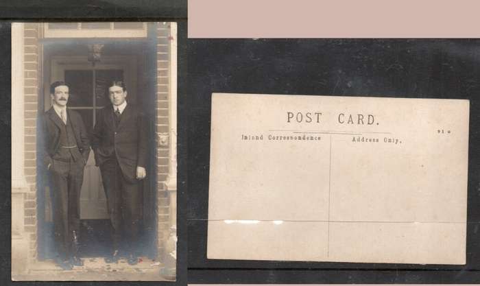 Two men of substance dressed and groomed posed in door way, photo