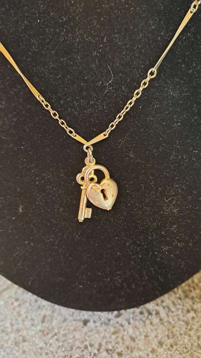 Gold toned necklace with heart and key