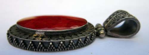 Red coral set in a beautifully decorative sterling silver hinged pendant.