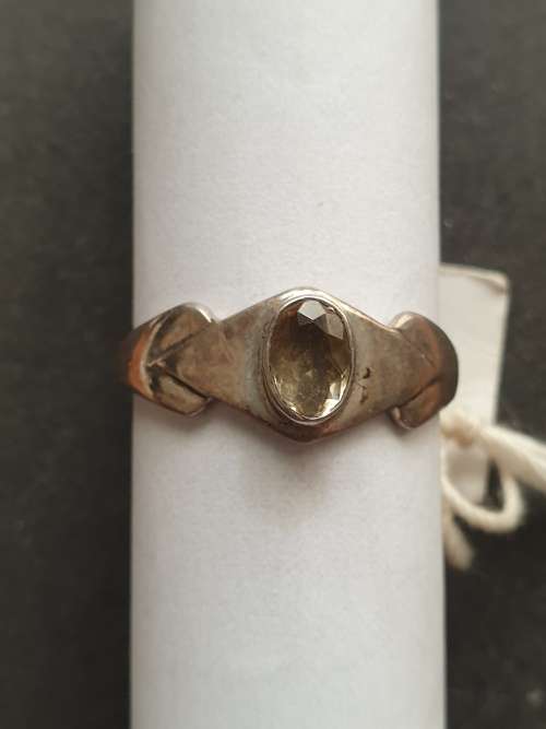 A siver ring with yellow stones cushion cut stone