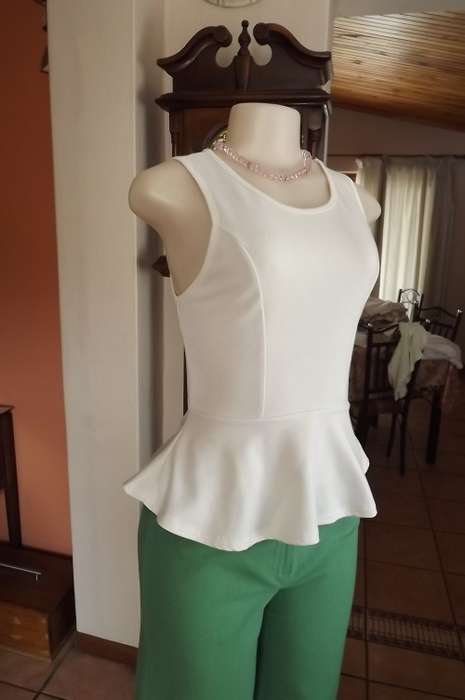 White peplum top by RT in stretch polyester.Size 36/12.Rounded neckline.Sleeveless