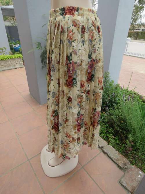Permanent pleated silky polyester skirt in beige with colourful floral pattern.Size 40/16