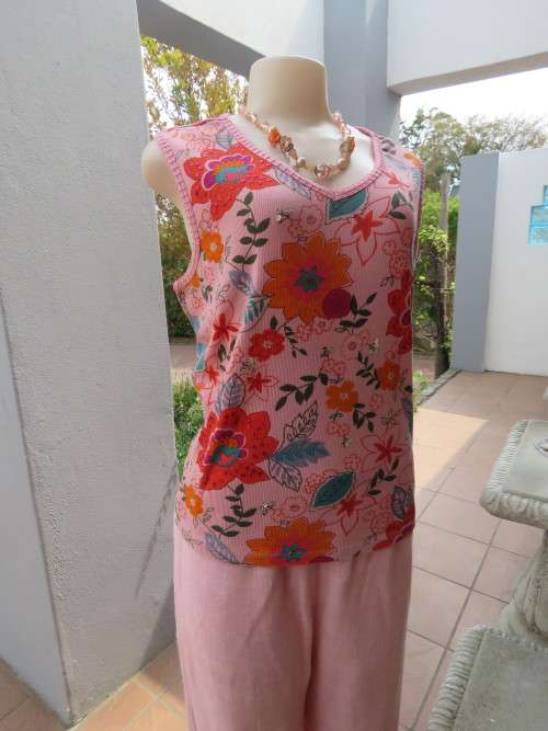 Pink sleeveless t shirt with bold floral pattern and sequin decoration.Size 42/18.Good condition