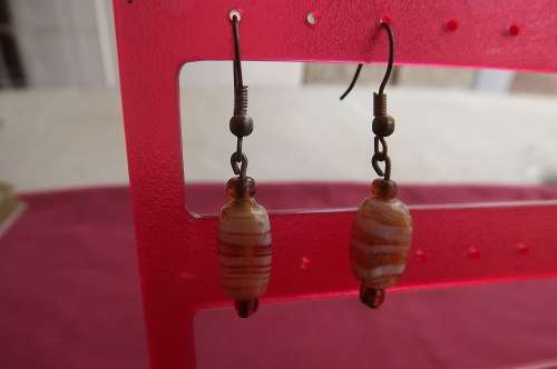 Pair of light brown piercing stone hanging earrings. As new