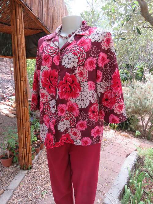 Eyecatching bold floral top in 100% wash + wear polyester by CASUAL AMERICAN.