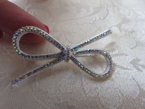 Silver toned bow design brooch with small glimmer stones.Length 5.2cm.New item.