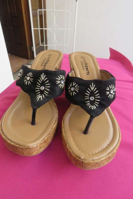 Pair of wedge heel sandals.Slip on style. Black band with embroidery and stones. Cork heels, Size 6
