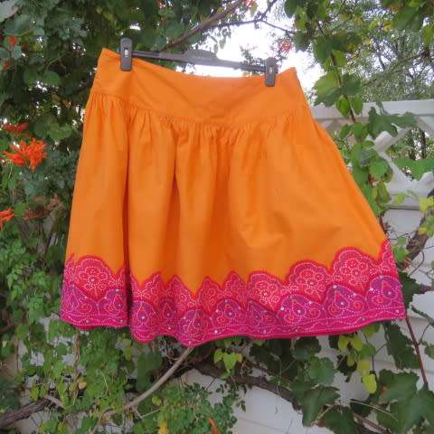 Cheerful yoked skirt in orange with gathered wide bottom size 40/16. Sequined border.New condition.