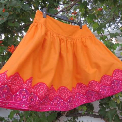 Cheerful yoked skirt in orange with gathered wide bottom size 40/16. Sequined border.New condition.