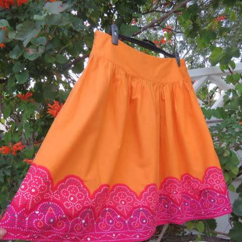 Cheerful yoked skirt in orange with gathered wide bottom size 40/16. Sequined border.New condition.