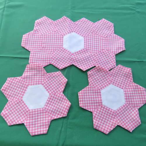 Pink and white 3 piece doily set made up in small hexagonal pieces. Sizs 1x33x18 cm and 2x20x20 cm.