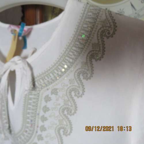 Pretty white slip over round neck top with front slit and tiestring.Patterned neckline.For 11/12 yr.