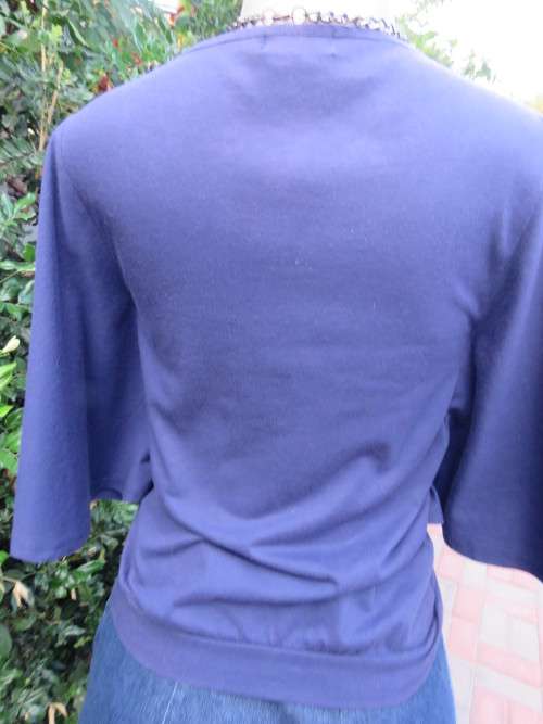 Must have navy cropped polycotton top with wide low bell sleeves. Studs on yoke front.Size 34/10.