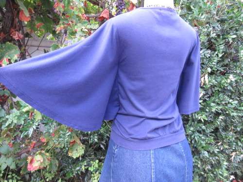 Must have navy cropped polycotton top with wide low bell sleeves. Studs on yoke front.Size 34/10.