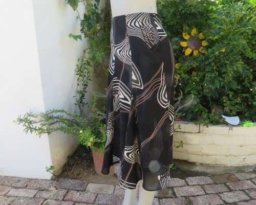 Sassy black paneled sheer polyester skirt with cream/wheat geometric patterns.Size 32/8.Bandless.