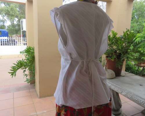 Sleeveless white 100%cotton embossed empire top.Crossover bust.Floral print decoration.42