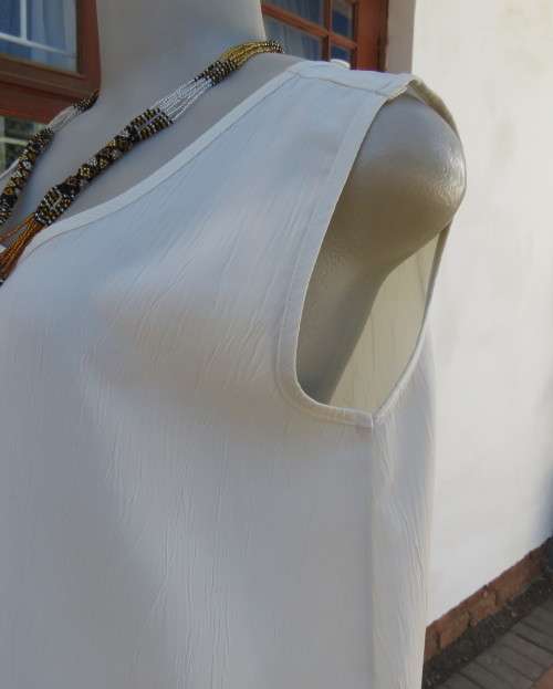 As new rich cream sleeveless cami style slip over top in creased polyester by IN CLOTHING size 36/12