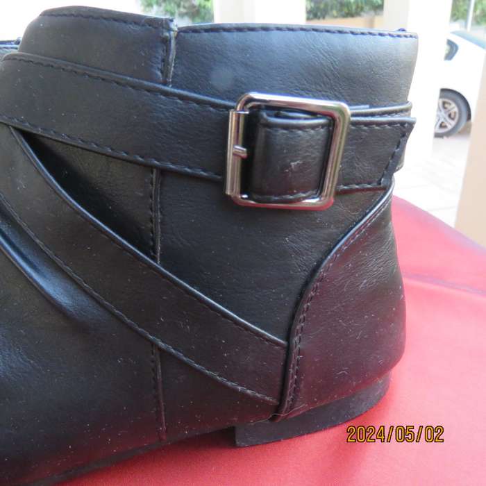 Pair of black faux leather booties in size 9 with side zips. Also an adjustable strap. Very good con