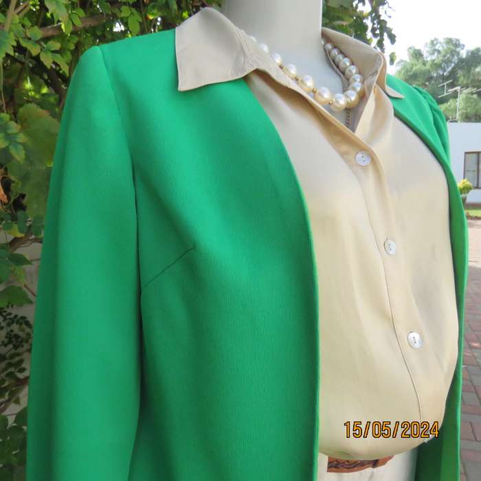 Charming forest green fully lined long sleeve open/collarless jacket.Size 34. Fine stretch polyester