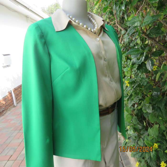 Charming forest green fully lined long sleeve open/collarless jacket.Size 34. Fine stretch polyester